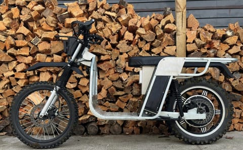 Galvbike parked against a stacked woodpile